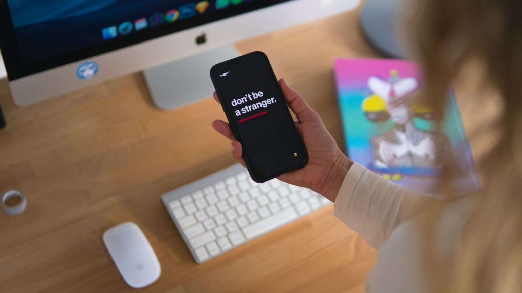 person reading phone that reads Dont be a Stranger